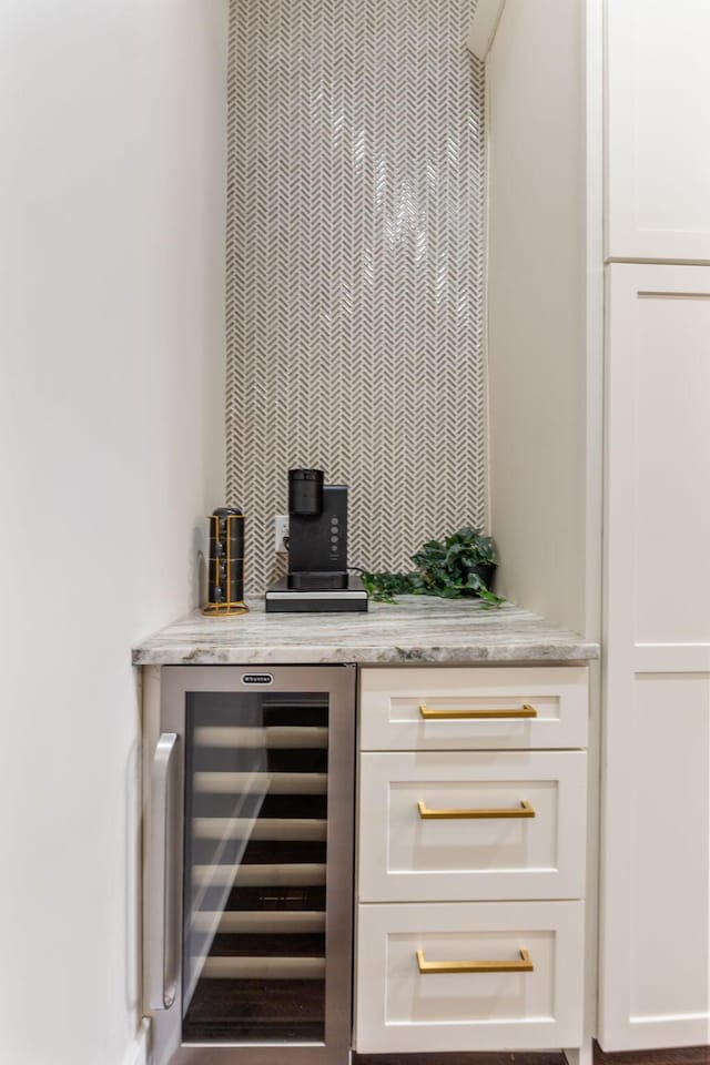 bar with decorative backsplash, beverage cooler, and a dry bar