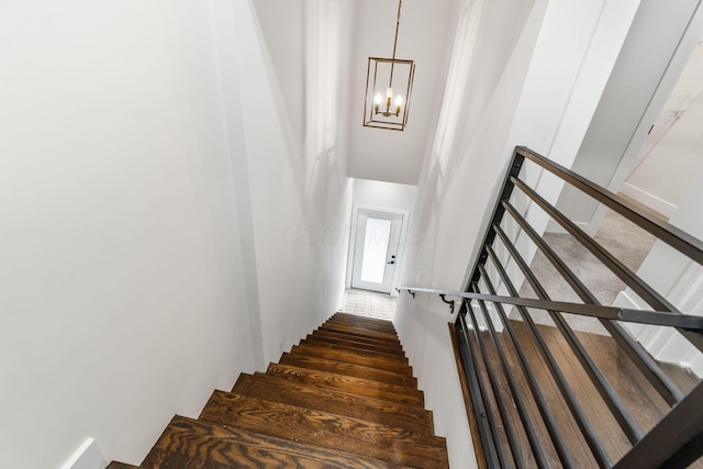 stairs featuring a chandelier