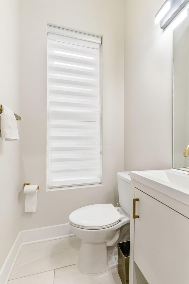 bathroom with baseboards, vanity, toilet, and tile patterned floors