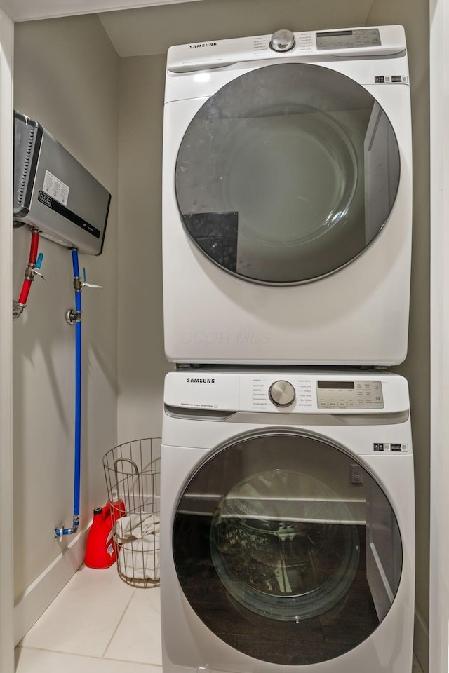 laundry area with laundry area, tile patterned flooring, and stacked washer / dryer