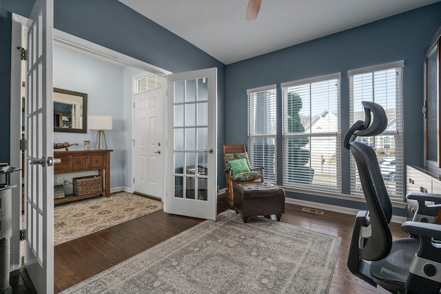 office space with ceiling fan, visible vents, baseboards, and wood finished floors