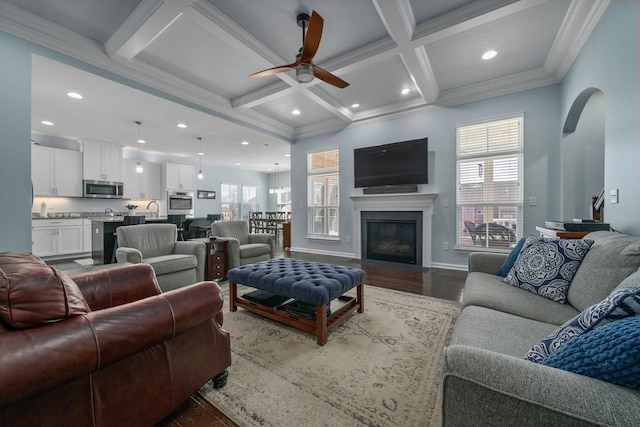 living room with beam ceiling, plenty of natural light, and coffered ceiling