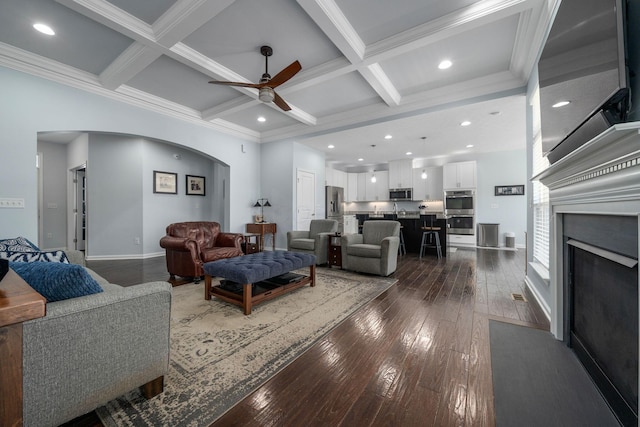 living area with arched walkways, coffered ceiling, beam ceiling, and hardwood / wood-style flooring