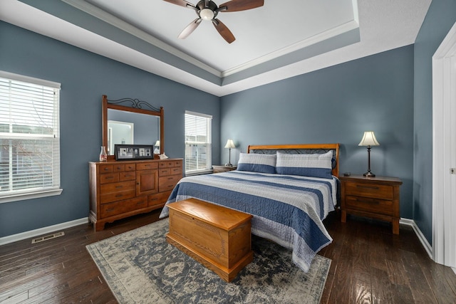 bedroom with baseboards, a raised ceiling, and hardwood / wood-style floors