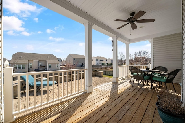 wooden deck featuring outdoor dining area, a residential view, and ceiling fan