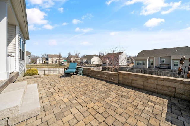 view of patio featuring a residential view and fence