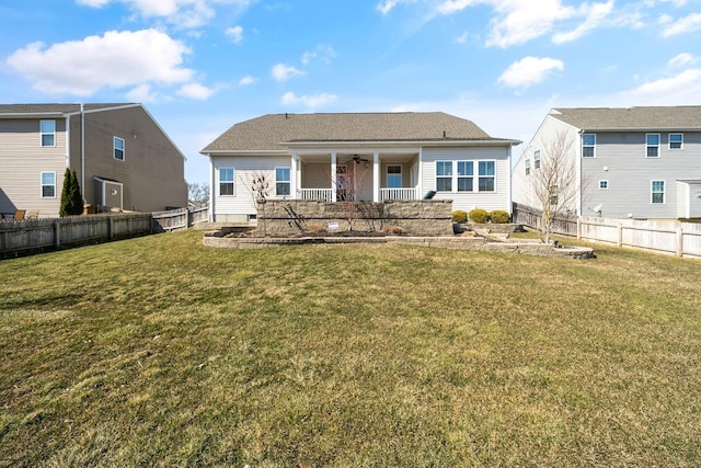 rear view of house with a yard, a fenced backyard, covered porch, and a ceiling fan