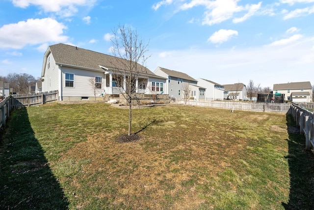 rear view of house with a yard and a fenced backyard