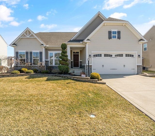 craftsman-style house with a front lawn, stone siding, board and batten siding, concrete driveway, and a garage