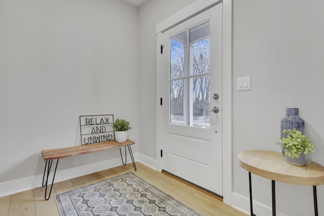 doorway with baseboards and light wood-style floors