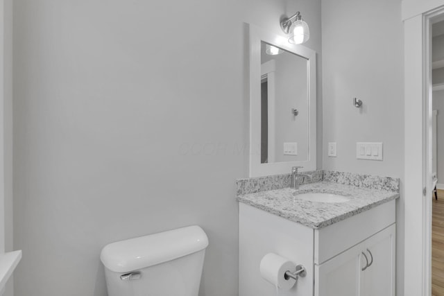 bathroom with wood finished floors, vanity, and toilet