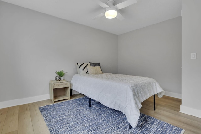 bedroom with ceiling fan, baseboards, and wood finished floors