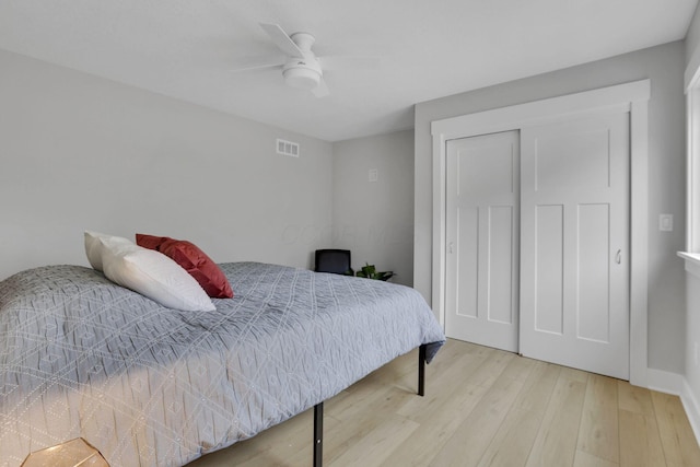 bedroom with a ceiling fan, a closet, visible vents, and wood finished floors