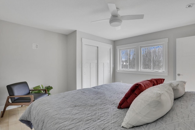 bedroom with a closet, wood finished floors, and a ceiling fan