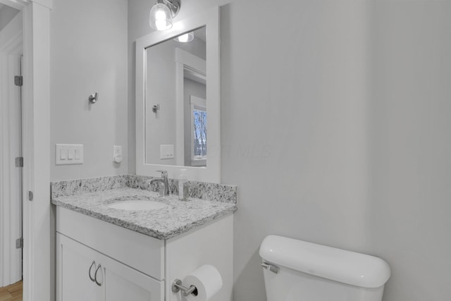 half bathroom with vanity and toilet