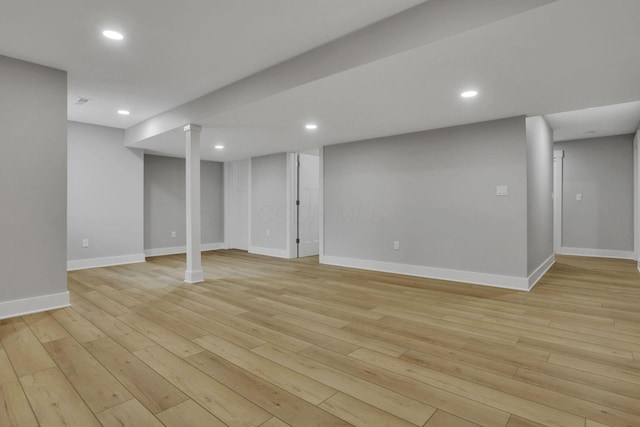 finished below grade area featuring baseboards, light wood finished floors, and recessed lighting