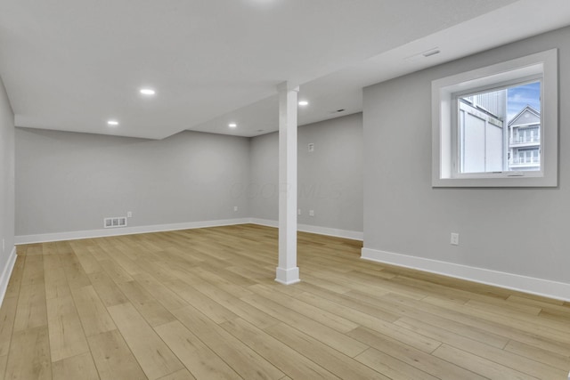 below grade area with recessed lighting, visible vents, light wood-style flooring, and baseboards