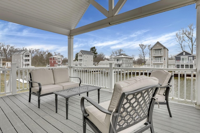 deck with a water view, a residential view, and an outdoor living space