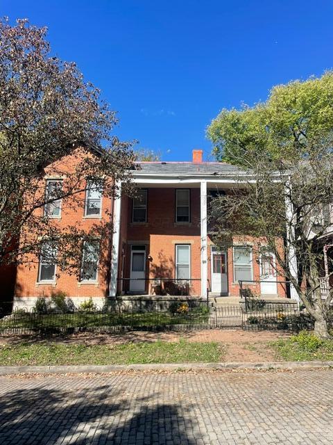 view of front of property with a fenced front yard and brick siding