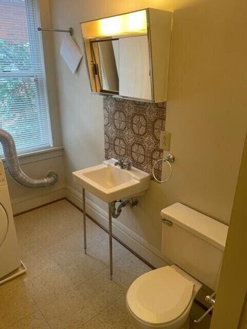 bathroom with toilet, baseboards, a sink, and tile patterned floors