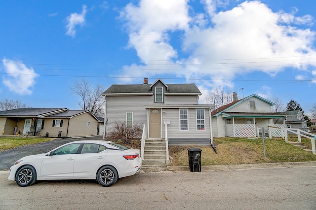 view of front of house with roof with shingles and fence