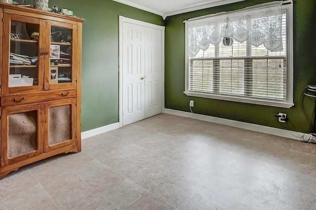 unfurnished bedroom with ornamental molding, a closet, and baseboards