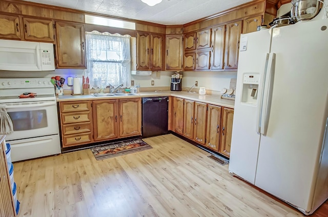 kitchen featuring white appliances, brown cabinetry, light wood-style flooring, light countertops, and a sink