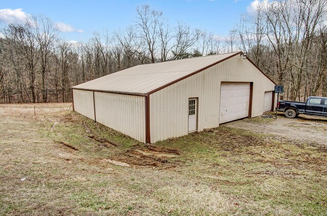detached garage featuring a view of trees