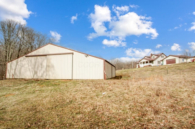 view of yard featuring a garage, a pole building, and an outdoor structure