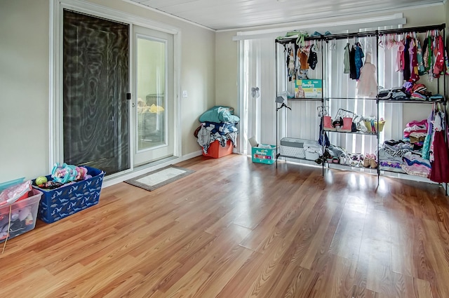 interior space featuring ornamental molding, access to exterior, and wood finished floors
