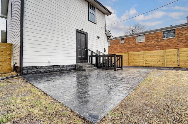 back of property with entry steps, a patio area, and fence