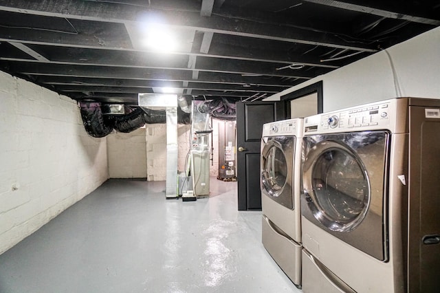 unfinished below grade area featuring washing machine and dryer and water heater