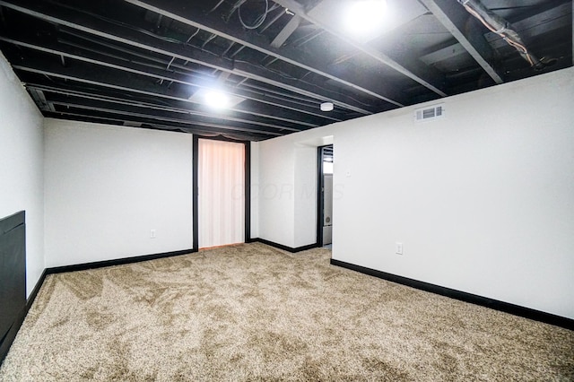 finished basement with carpet, visible vents, and baseboards