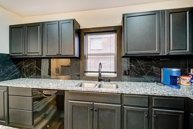 kitchen featuring light stone counters, black dishwasher, a sink, and decorative backsplash