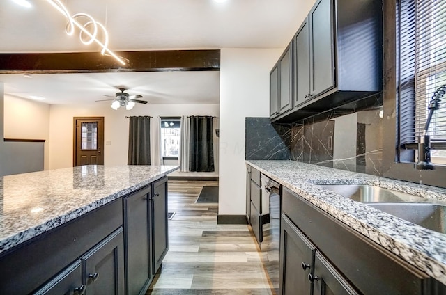 kitchen with tasteful backsplash, ceiling fan, beamed ceiling, light stone countertops, and light wood-style floors