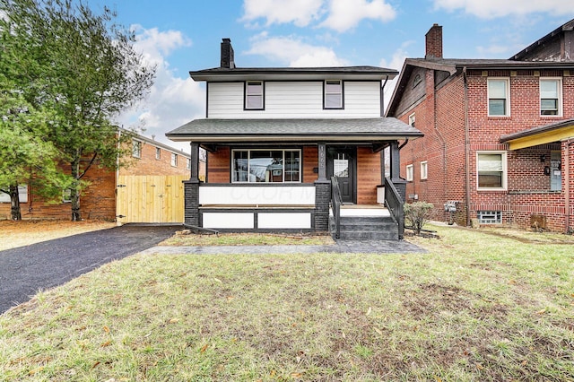 view of front facade featuring a porch, a front yard, a gate, and a shingled roof