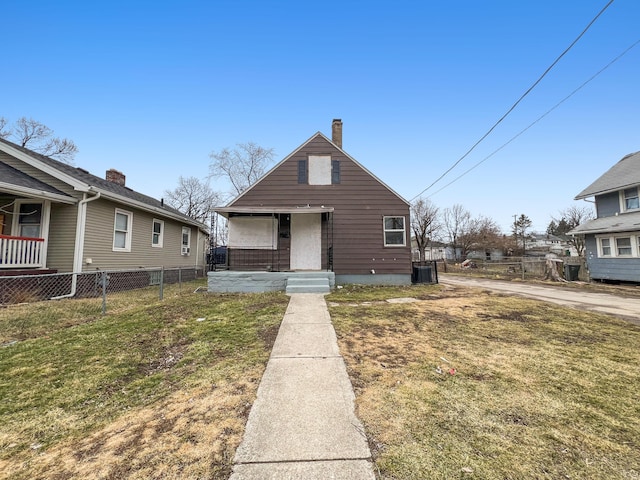 bungalow with a front yard, fence, and central AC unit