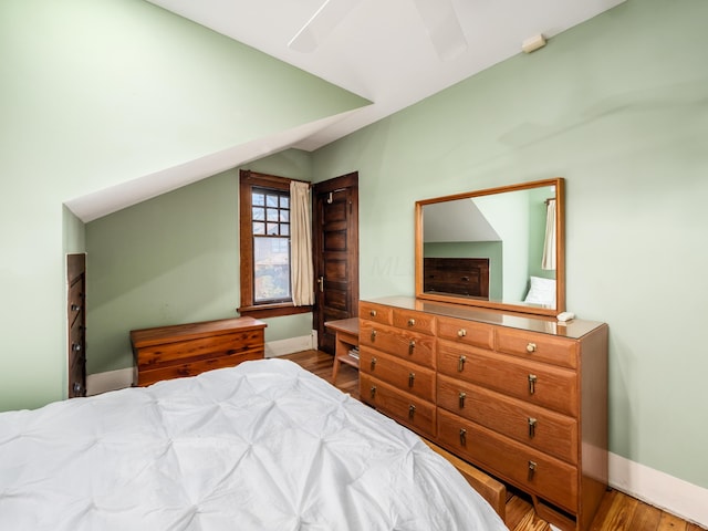 bedroom with wood finished floors, a ceiling fan, and baseboards