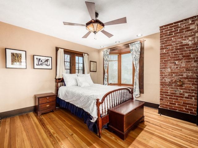 bedroom with ceiling fan, french doors, light wood finished floors, and baseboards