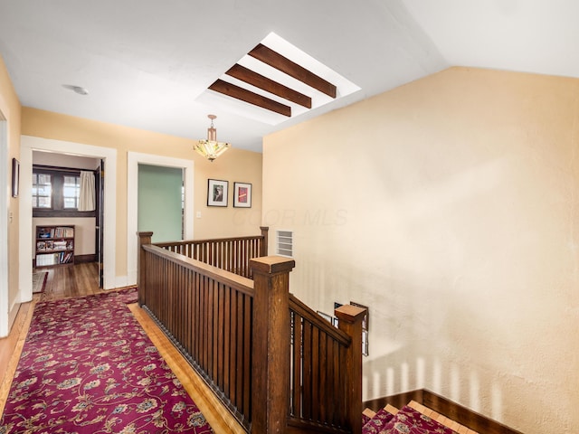 corridor featuring lofted ceiling, visible vents, an upstairs landing, and light wood-style floors