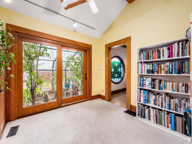 interior space featuring carpet, visible vents, vaulted ceiling, track lighting, and baseboards