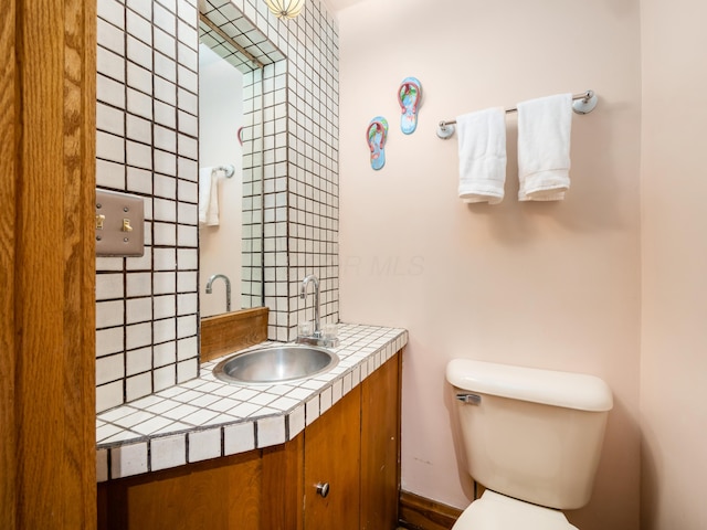 half bathroom featuring decorative backsplash, vanity, and toilet