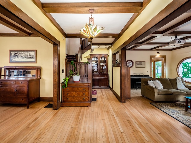 foyer entrance featuring stairway, beamed ceiling, light wood-style flooring, and baseboards