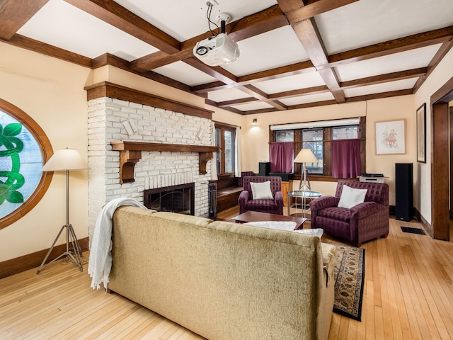 living room featuring a brick fireplace, coffered ceiling, light wood-style flooring, and baseboards