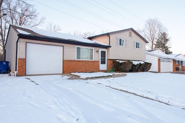 tri-level home featuring a garage and brick siding