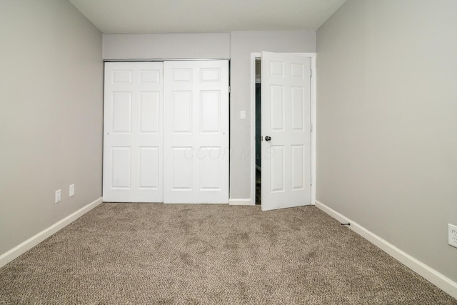 unfurnished bedroom featuring a closet, carpet, and baseboards