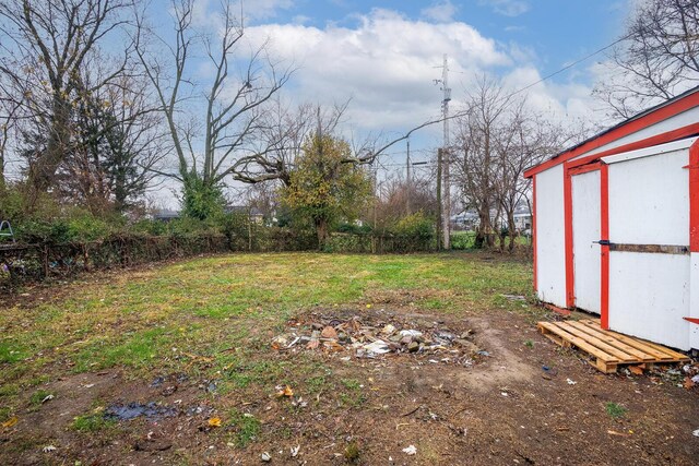 view of yard featuring fence private yard, a storage shed, and an outbuilding