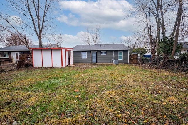 rear view of property with a storage shed, a fenced backyard, a lawn, and an outdoor structure