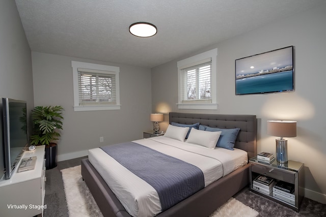 bedroom with carpet floors, multiple windows, a textured ceiling, and baseboards