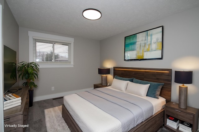 bedroom with a textured ceiling, carpet floors, and baseboards